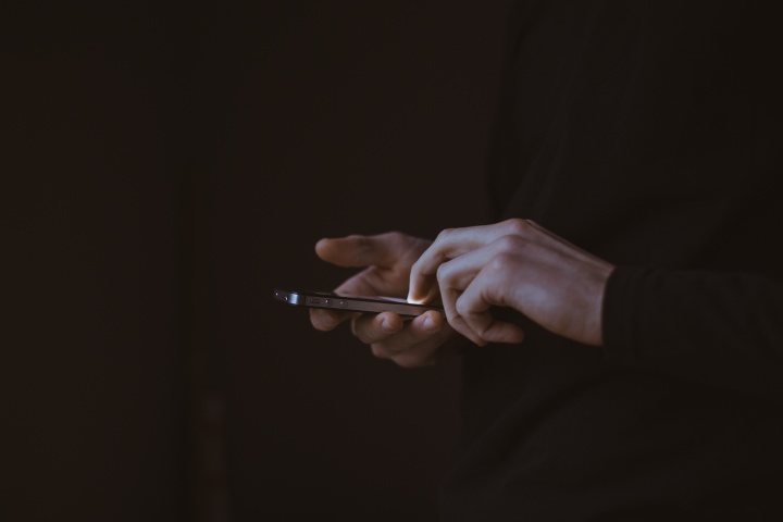 A person using a smartphone in the dark.