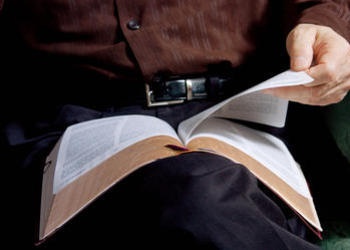 A man holding a Bible in his lap.