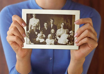 A woman holding an old family photo.