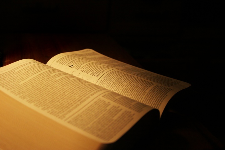 An open Bible in a dark room.