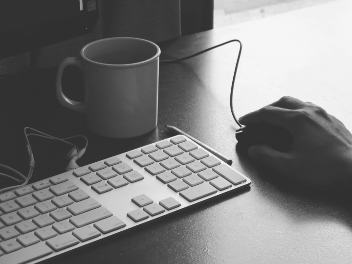 A person's hand on top of a computer mouse ready to click.