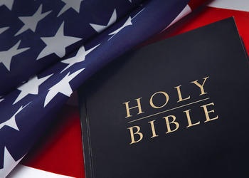 Holy Bible on laying on top of United States flag