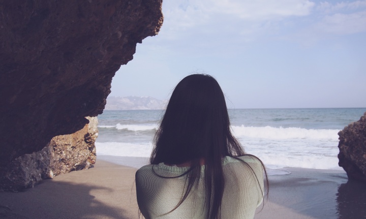 Woman looks at the ocean.