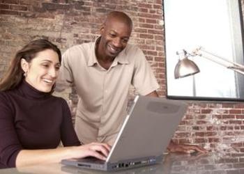 A man and woman working together on a laptop.