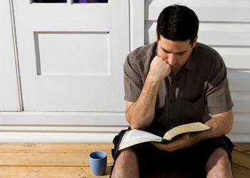 A man sitting and reading the Bible.