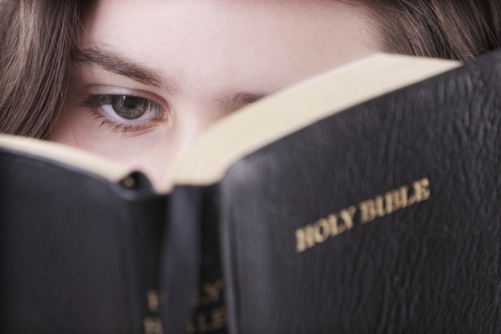 A woman looking at a Bible.