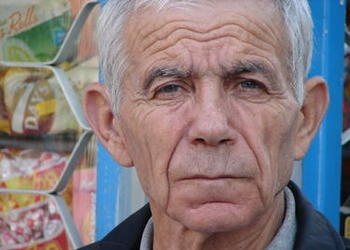 An elderly man looking at the camera.