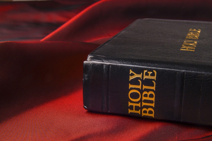 A Bible sitting on a red piece of cloth.