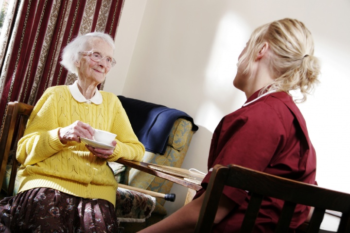 A young woman visiting with an elderly lady.