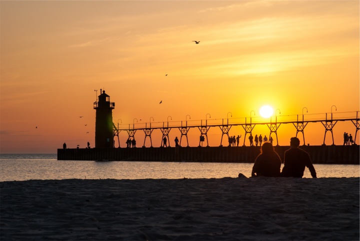 Sunset over a pier going into the ocean.