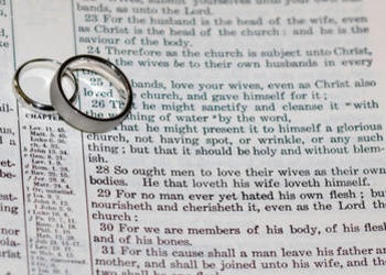 Wedding rings on top of Bible scripture - Ephesians 5:22-21