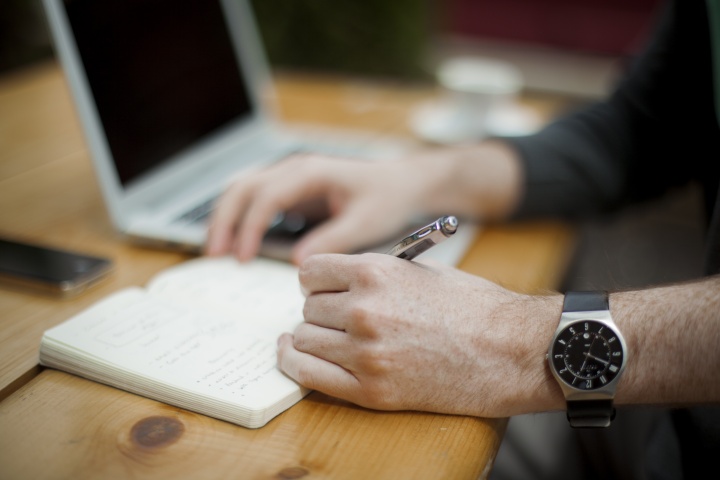 A man writing in a journal.