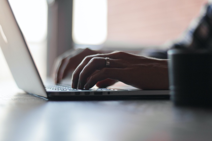 a pair of hands typing at a laptop computer