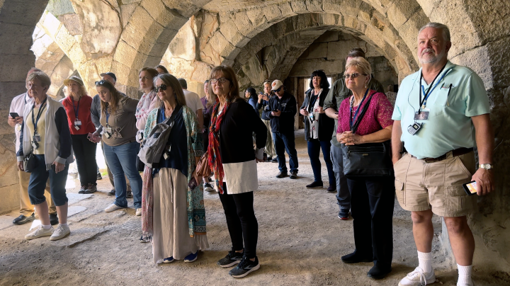 a group of people standing surrounded by ancient architecture