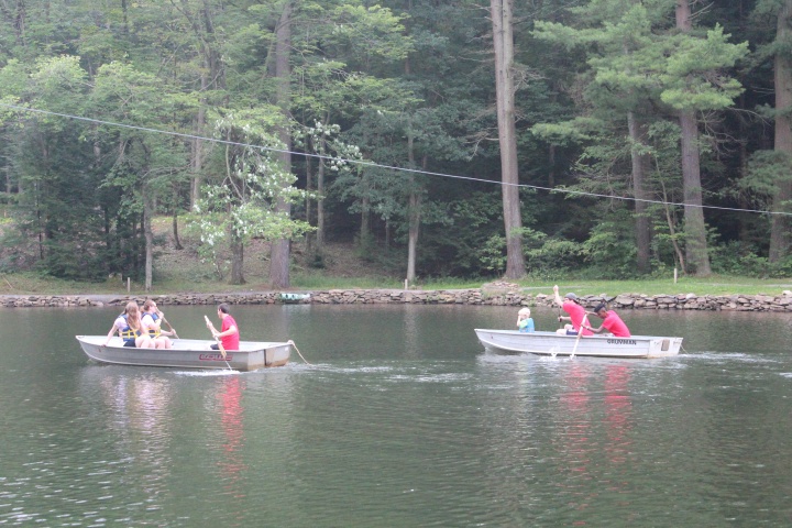 Campers in row boats on the river. 