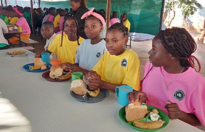 a group of children outdoors under a tent