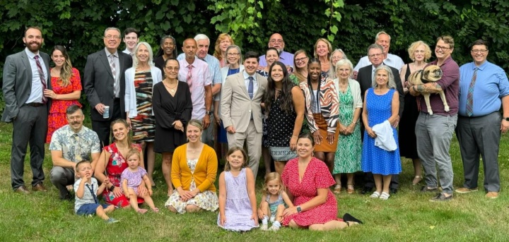 a large group of people seated and standing outside