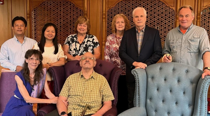 eight people standing and seated indoors