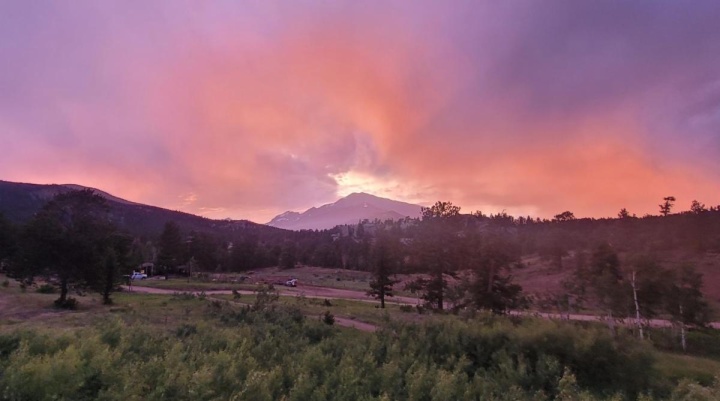 A landscape scene with a pink sunset sky