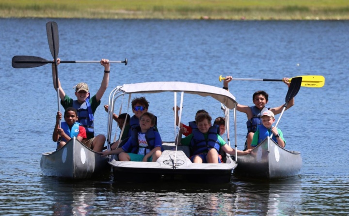 a group of campers in canoes on a lake