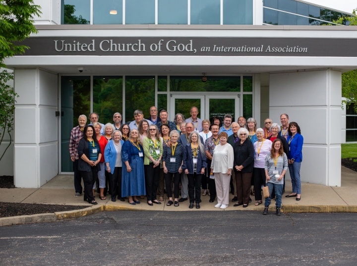 A group of people standing outside a building that says United Church of God