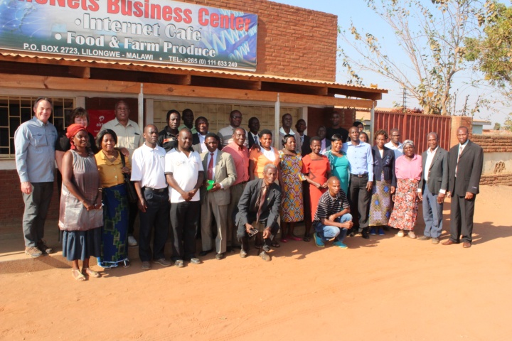 Darris and Debbie McNeely with brethren stand in front of the LifeNets Internet Cafe in Malawi.