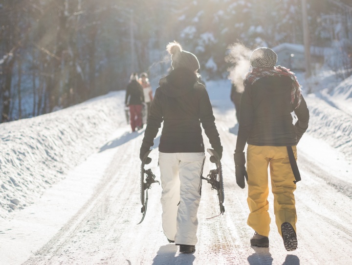 Two women walking and talking together in the snow.