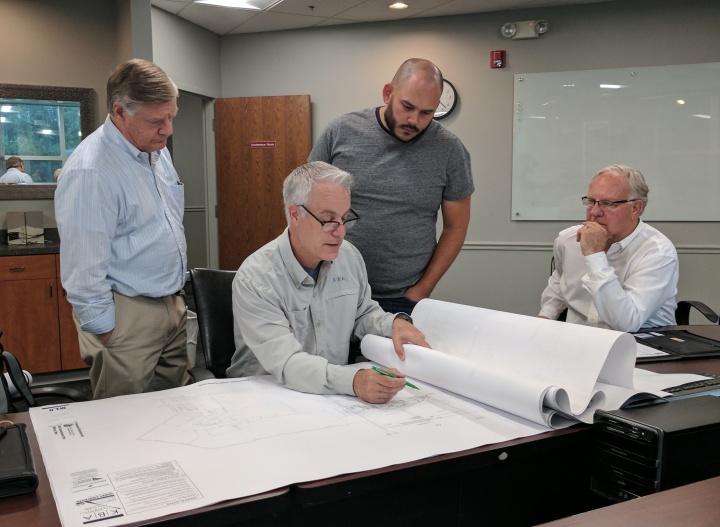 Peter Eddington and Rudy Rangel look at the new addition plans with Mark Bredemeier and Mike Barnard. 