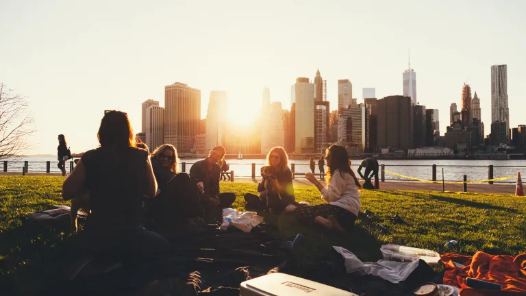 There is certainly a point in sharing our faith with others, but the method by which we share our faith is equally if not more important. A group of friends on blanket in a park talking.